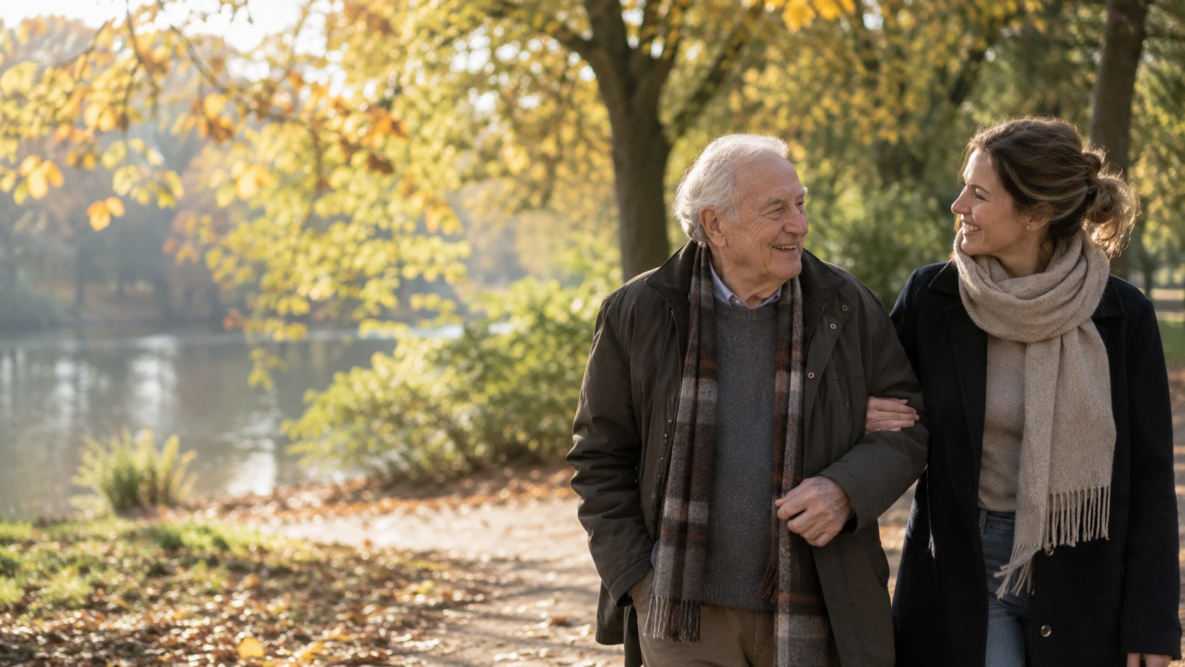 Betreuungskraft begleitet einen älteren Herrn beim Spaziergang im Herbstpark